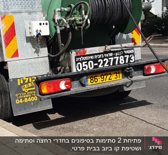 משאית ואקום עם צינור ירוק גדול מאחור